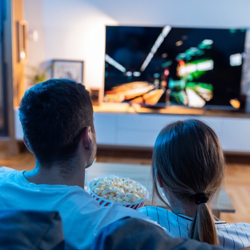 young couple watch film at romantic night in apartment and eat popcorn NexTV