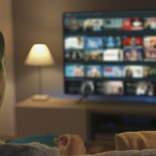 NexTV box young woman watching video on demand on her tv